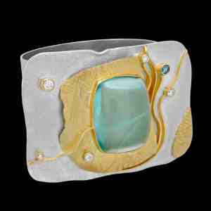 Custom sterling silver and 18kt yellow gold cuff with a cabochon aquamarine and diamonds. Shackle cuff | Shield Collection. FRIDA | Fine Jewellery.