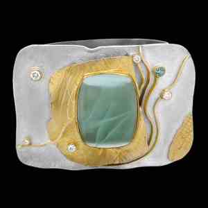 Custom sterling silver and 18kt yellow gold cuff with a cabochon aquamarine and diamonds. Shackle cuff. Front | Shield Collection. FRIDA | Fine Jewellery.
