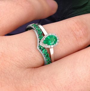 Custom 18kt white gold engagement ring with a pear-shaped emerald and diamond halo with emerald 'v' wedding band | Classic Engagement. FRIDA | Fine Jewellery.