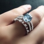 Custom 18kt white gold solitaire engagement ring with an eagle claw set natural blue-grey sapphire and diamonds. Perspective. FRIDA | Fine Jewellery.