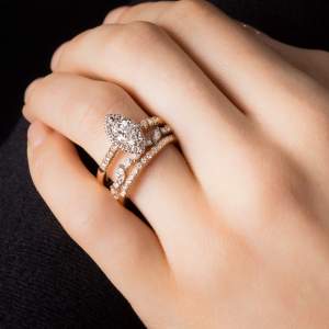 Custom 18kt pink gold engagement ring with a marquise-cut diamond and a halo of diamonds. Marquise diamond wedding band ring. Perspective | Classic. FRIDA | Fine Jewellery.